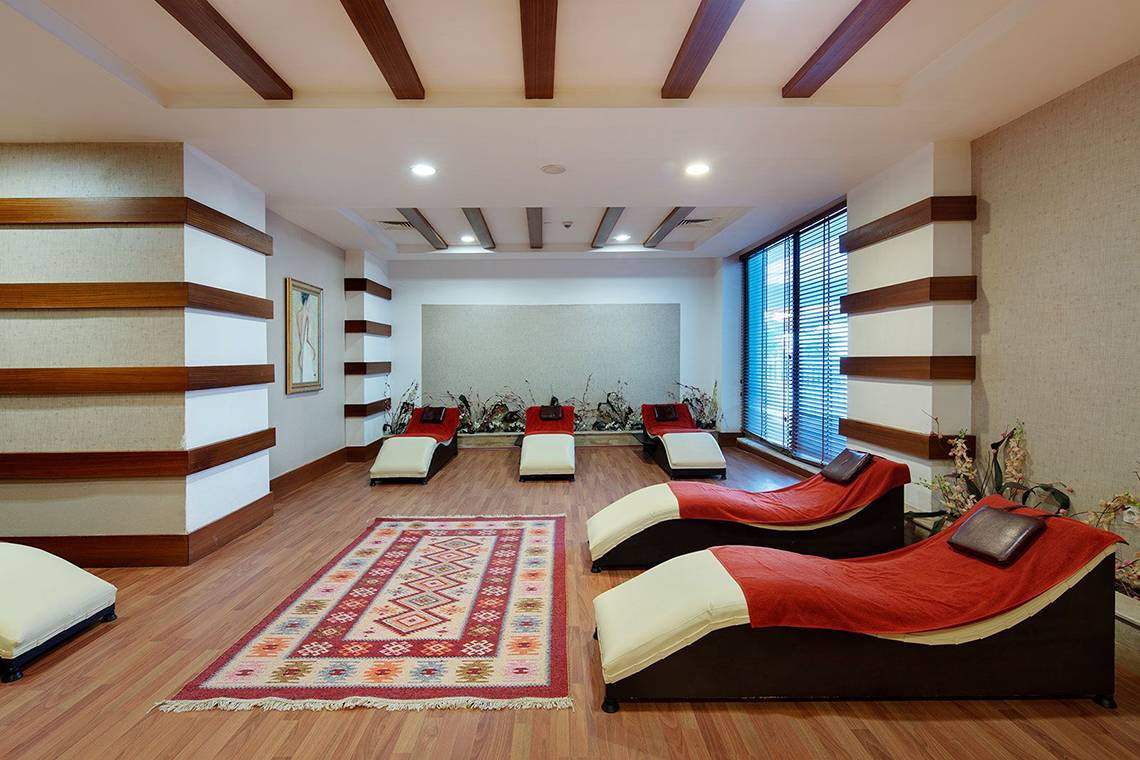 Relaxationslounge im Alba Queen Hotel mit Liegen und Teppich auf Holzboden.