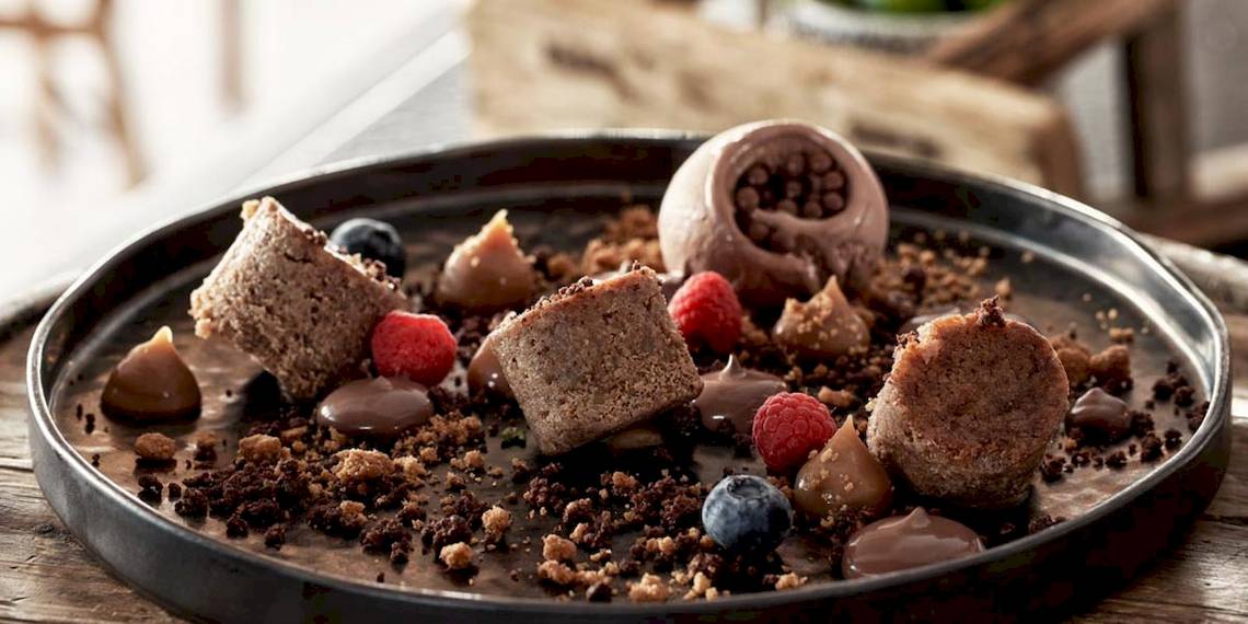 Schokoladen-Dessert-Platte im Myconian Kyma Hotel mit verschiedenen Früchten und Schokoladenstücken.