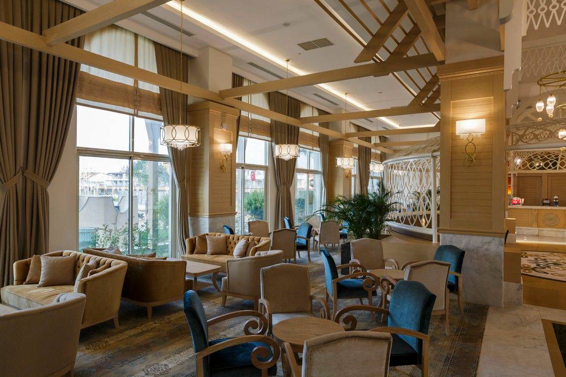 Lobby des Well Palace Side Hotels mit Sofas, Tischen und Beleuchtung.