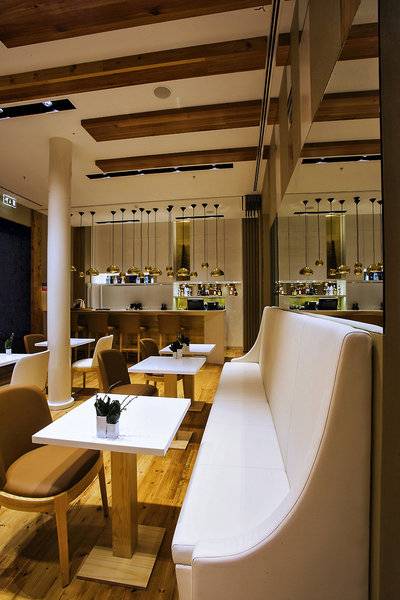 Der Innenraum des Portugal Boutique Hotels zeigt ein modernes Design mit weißen Möbeln und hängenden Lampen.