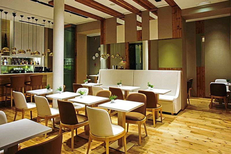 Innenbereich des Portugal Boutique Hotels mit weißen Tischen, Stühlen und Holzboden.