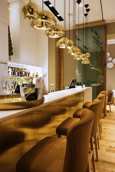 Rezeption im Hotel Portugal Boutique mit goldenen Leuchten und Barbereich.