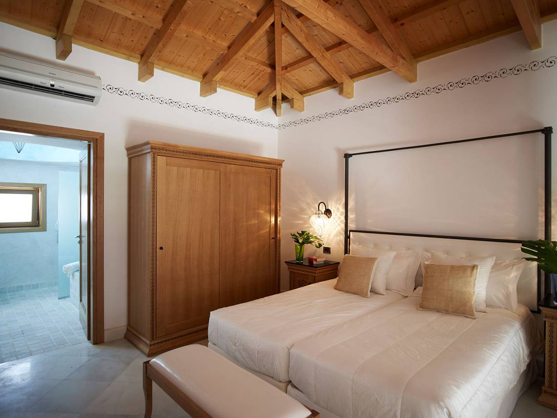 Schlafzimmer mit Doppelbett im Mitsis Blue Domes Resort & Spa