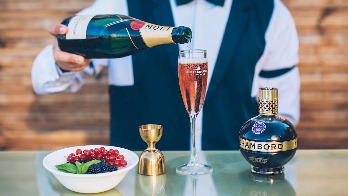 Ein Barkeeper schenkt ein Glas Moët & Chandon Champagner in einen Champagnerkelch am Iberostar Selection Playa de Palma.