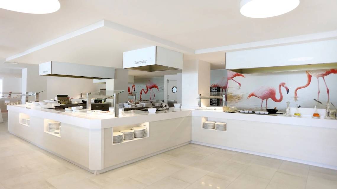 Speisebereich im Iberostar Selection Playa de Palma Hotel mit Flamingo-Wandgemälde und weißen Möbeln.
