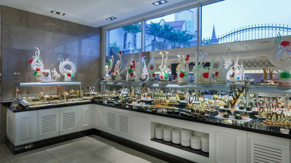 Buffet im Well Palace Side Hotel mit verschiedenen Desserts und Dekorationen.