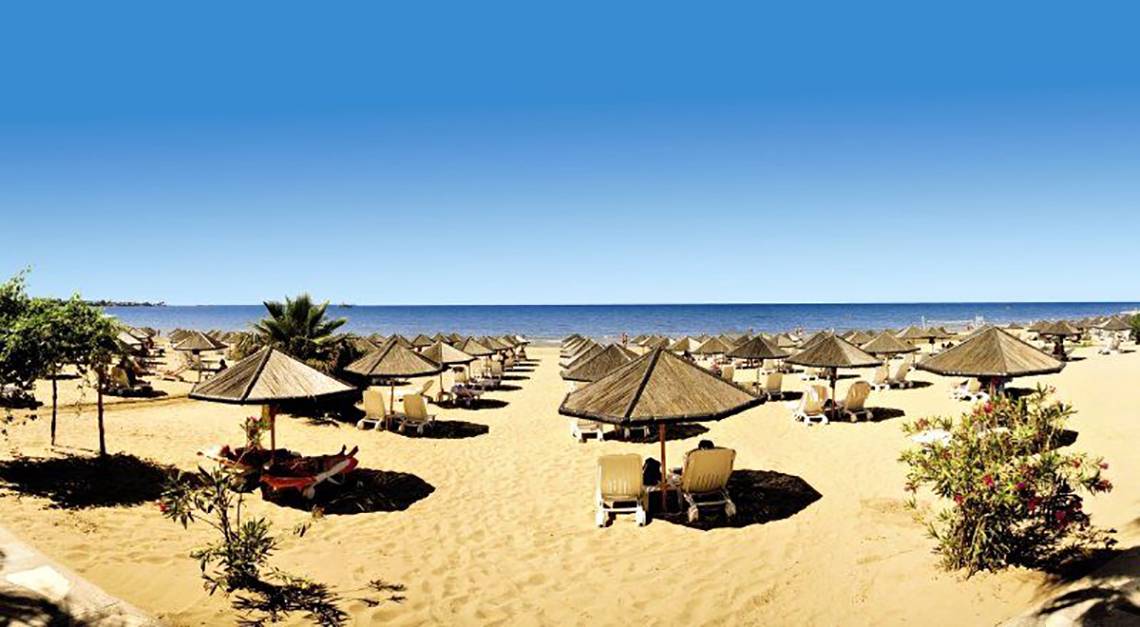 Defne Defnem Hotel Strand mit vielen Sonnenschirmen und Liegestühlen