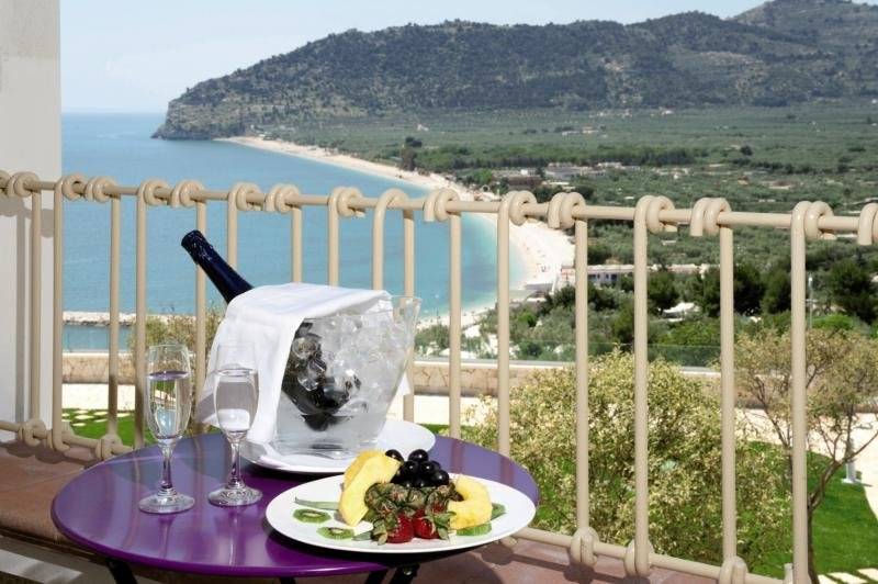 Aussicht vom Hotel Residence il Porto auf Meer und Strand mit Früchten und Wein auf der Terrasse.