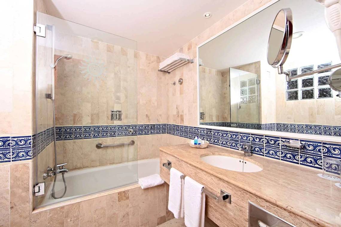 Badezimmer mit Badewanne, Spiegel und Handtüchern im Bahia Principe Grand Tulum