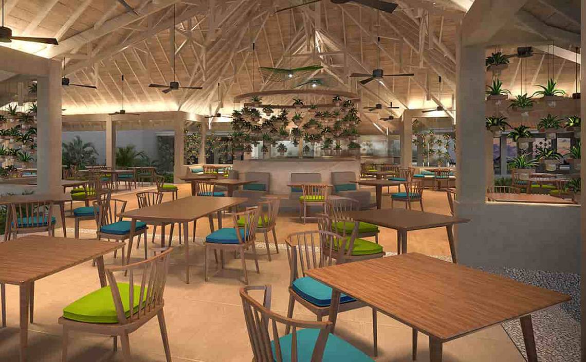 Innenansicht des Restaurants des Dhigali Maldives mit runden Tischen, Stühlen und Hängepflanzen.