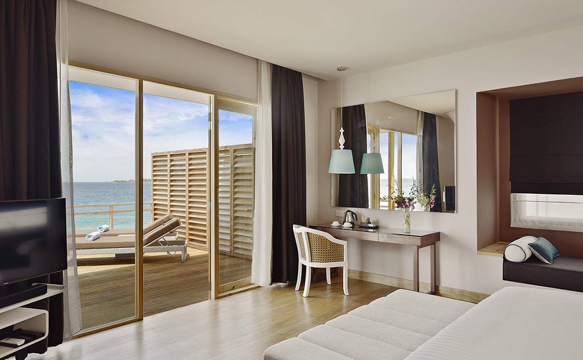 Suite Zimmer im Dhigali Maldives mit Meerblick, Schreibtisch, Spiegel und Fernseher.