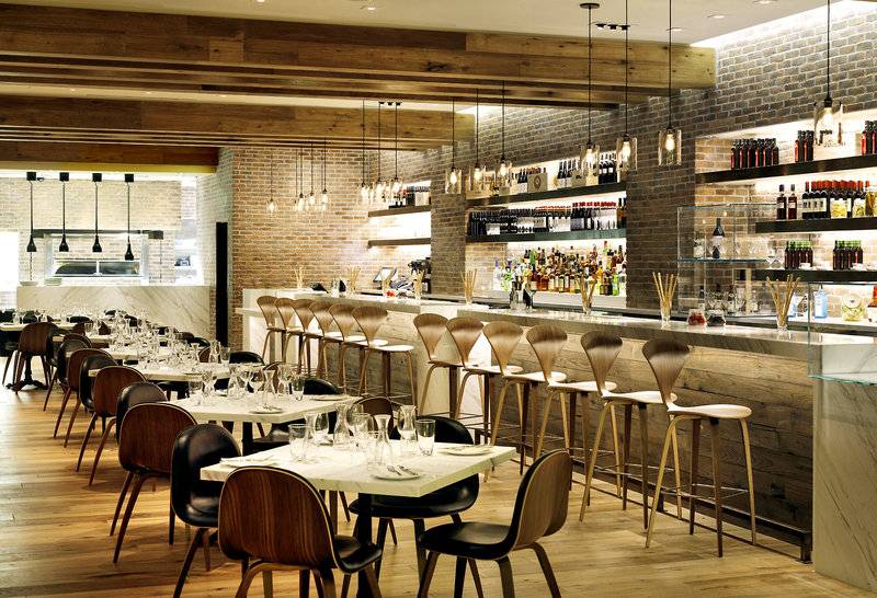 Innenbereich des Cosmopolitan Hotels in Las Vegas mit Bar, Tischen und Stühlen.