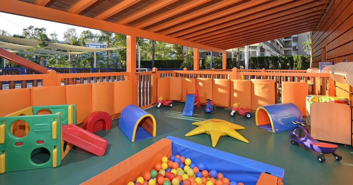 Spielplatz im Sol Principe Hotel mit bunten Spielsachen und einem überdachten Bereich.