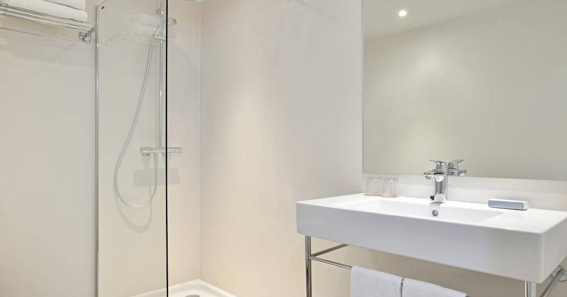 Ein Badezimmer mit Dusche, Waschbecken und Spiegel im Sol Principe Hotel.
