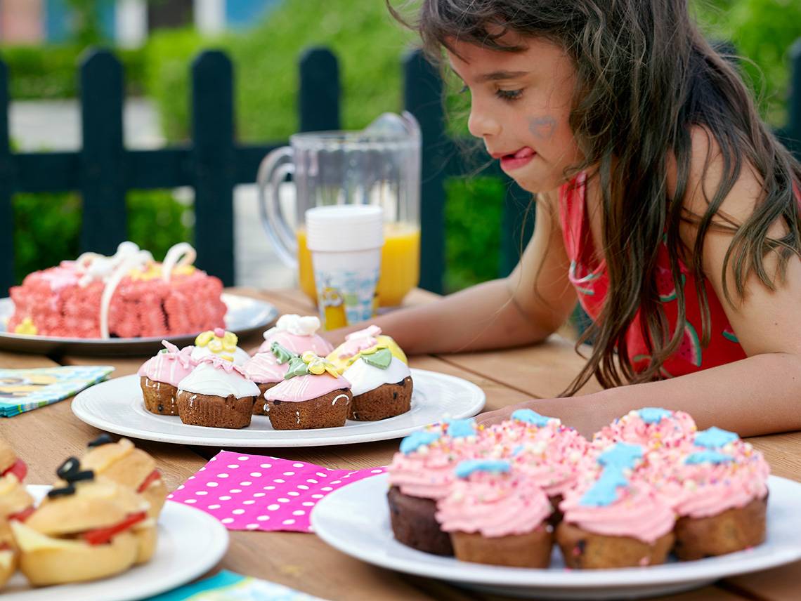 Ein Mädchen genießt ein Geburtstagsessen mit Cupcakes und anderen Leckereien im Hotel Aldemar Knossos Royal Resort.