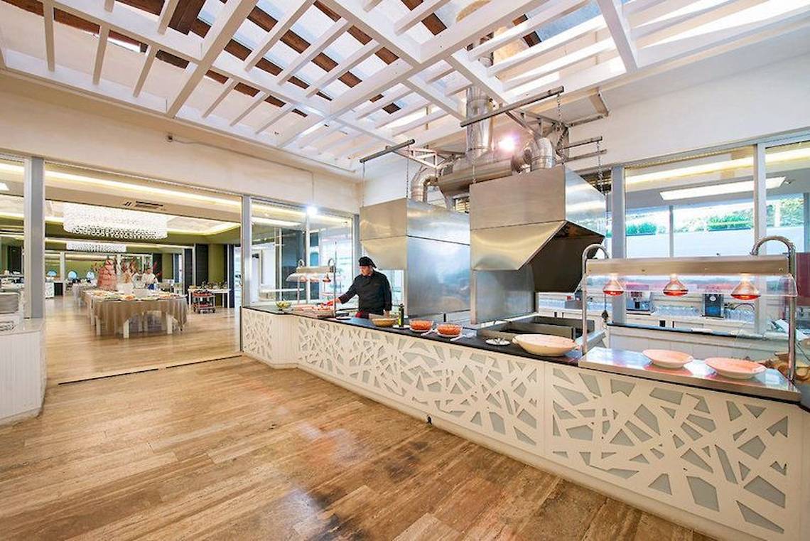 Innenansicht des Restaurants im VOI Alimini Resort mit Holzboden und moderner Einrichtung.