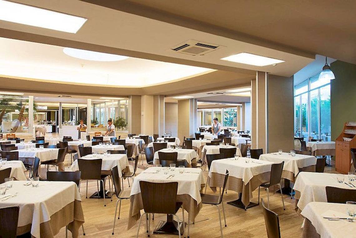 Innenansicht des Restaurants im VOI Alimini Resort mit geräumigen Tischen und Stühlen.