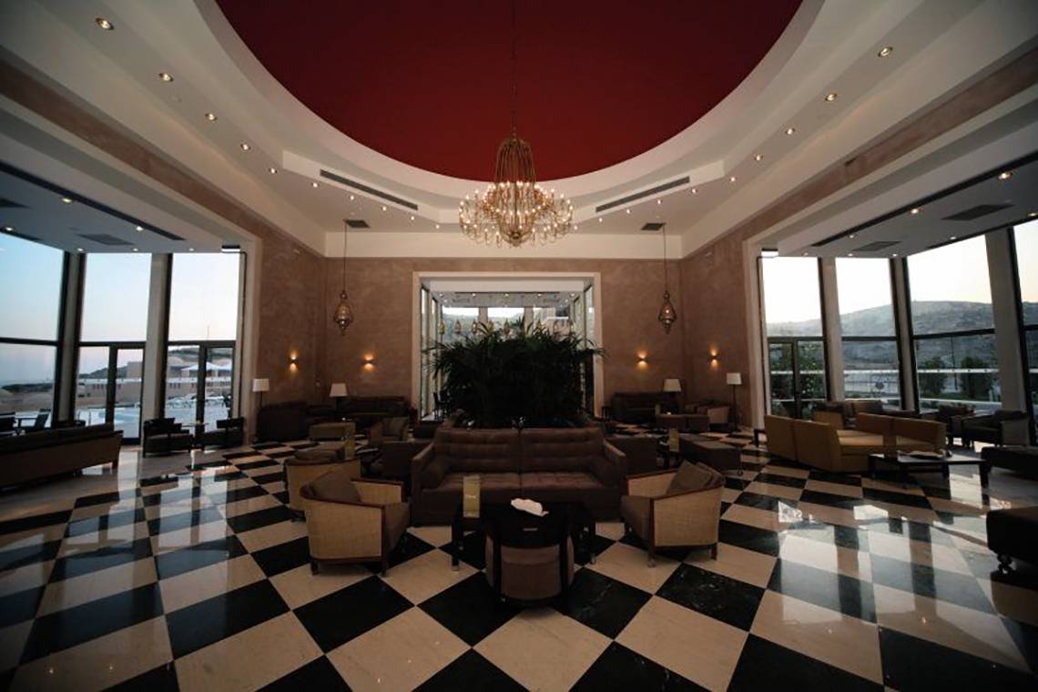 Lobby des Atlantica Belvedere Resorts mit schwarzem und weißem Schachbrettboden und einer großen Kristallkronleuchter.