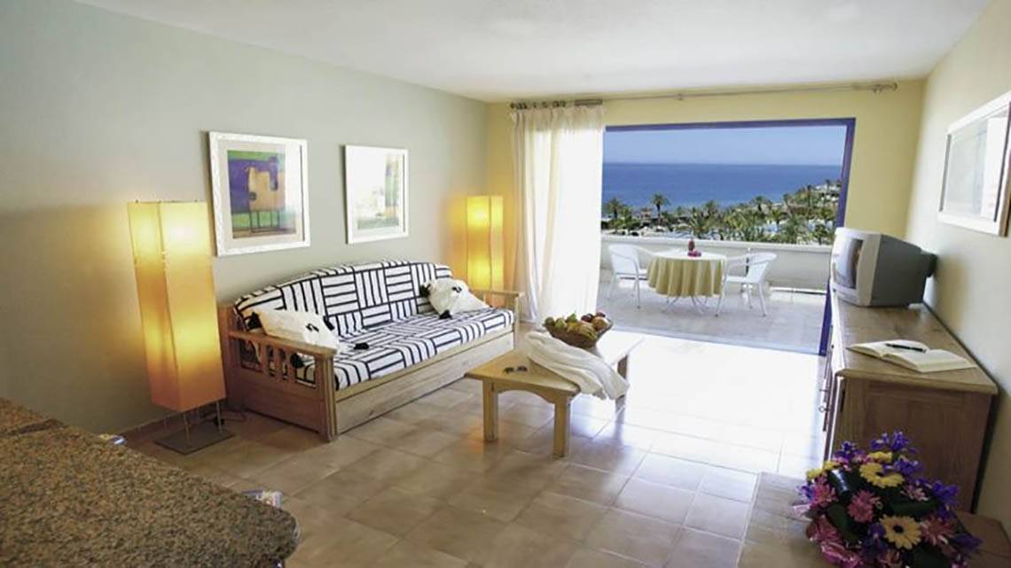 Balkonzimmer im LIVVO Lago Taurito Hotel mit Meerblick, Sofa und Tisch.