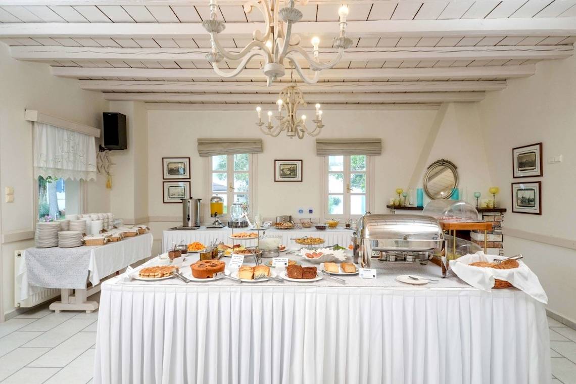 Frühstücksbuffet im Alkyoni Beach Hotel mit vielen Gerichten und einer weißen Tischdecke.