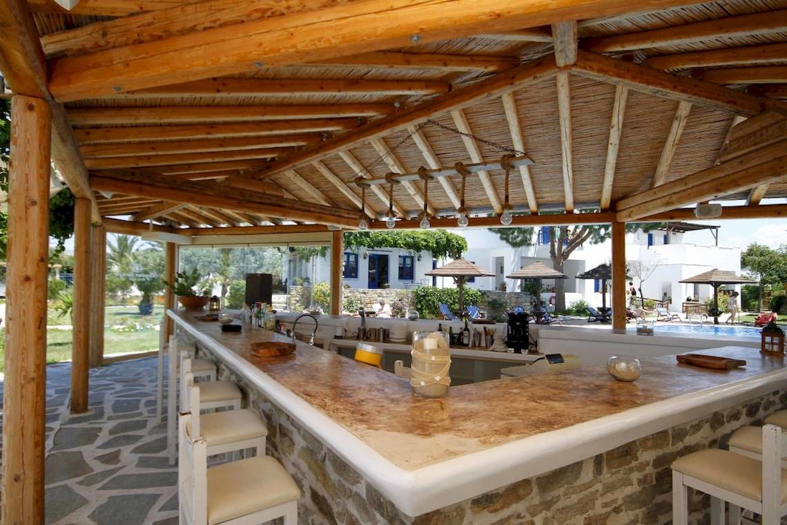 Bar im Freien im Alkyoni Beach Hotel mit Steinmauer und Holzdach