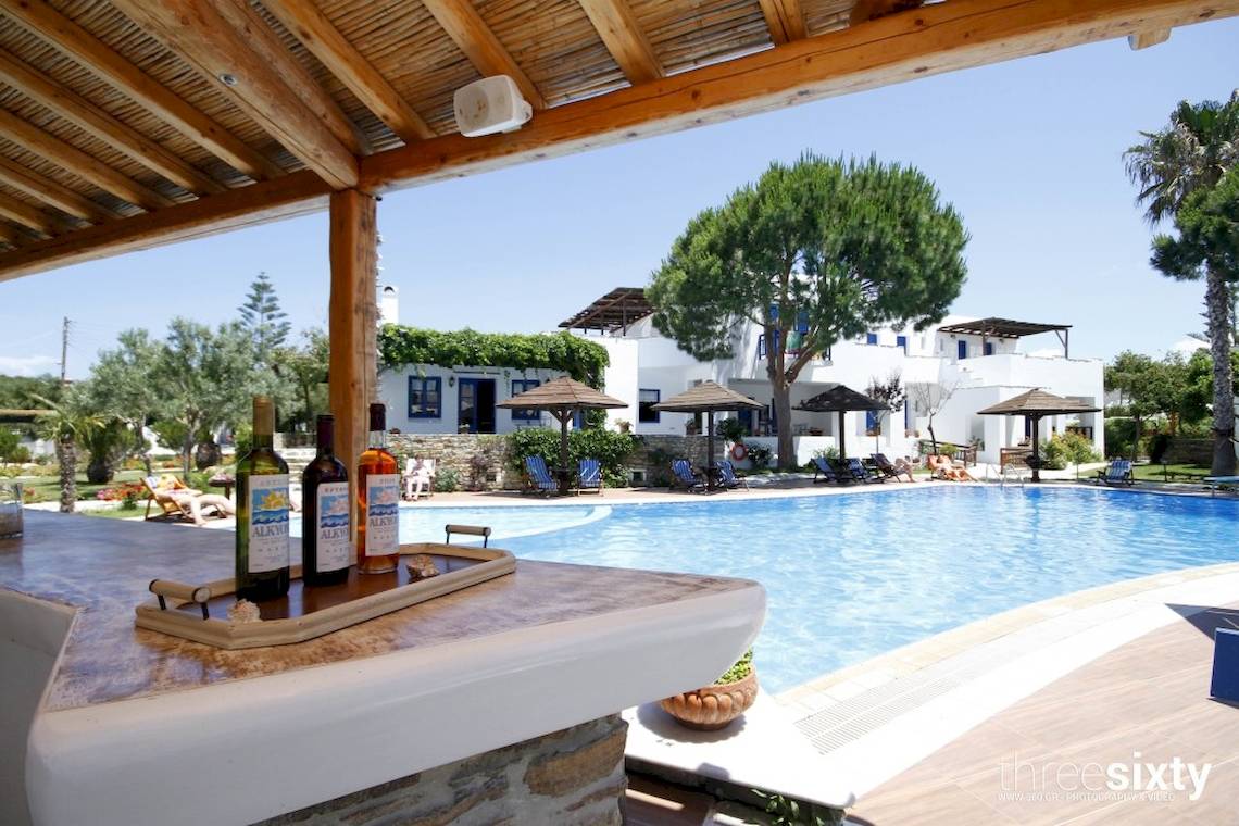Pool-Bar im Alkyoni Beach Hotel mit Flaschen und Sonnenschirmen