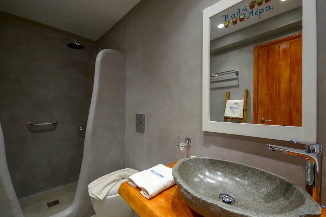 Badezimmer im Alkyoni Beach Hotel mit Dusche, Toilette und Waschbecken.