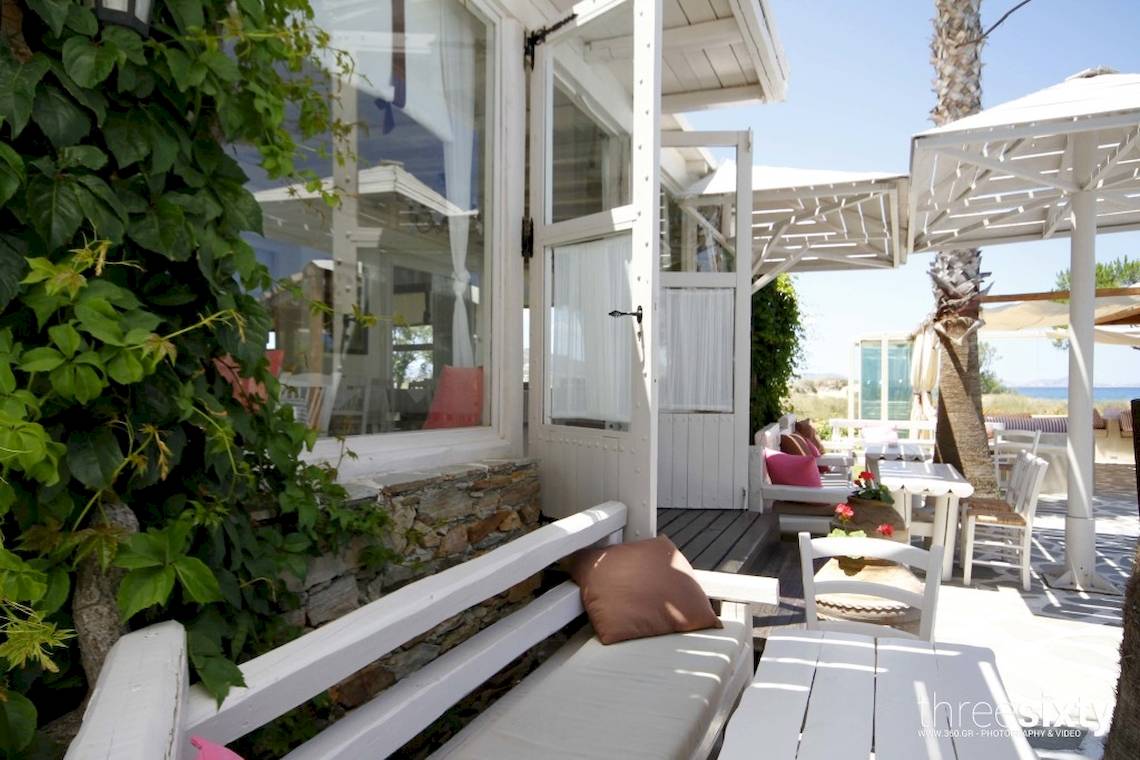 Außenbereich des Alkyoni Beach Hotels mit weißer Terrassenm�öbeln und grünen Pflanzen.