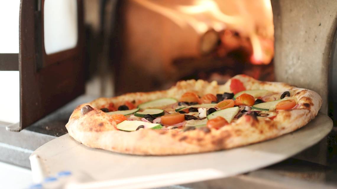 Eine Pizza mit Gemüse wird aus dem Ofen im Iberostar Selection Sabila Hotel genommen.
