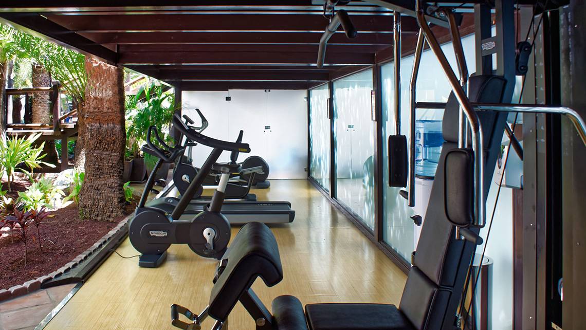 Fitnessbereich im Parque Tropical Hotel mit Cardiogeräten und Panoramafenstern.