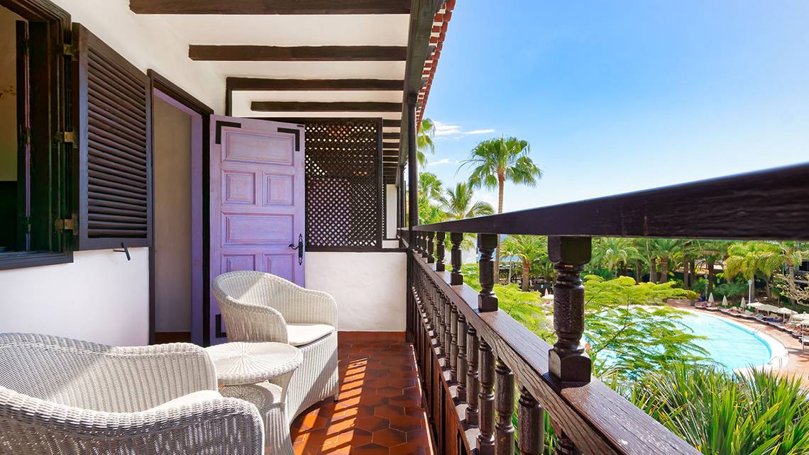 Terrasse des Parque Tropical Hotels mit Blick auf einen Swimmingpool und Palmen