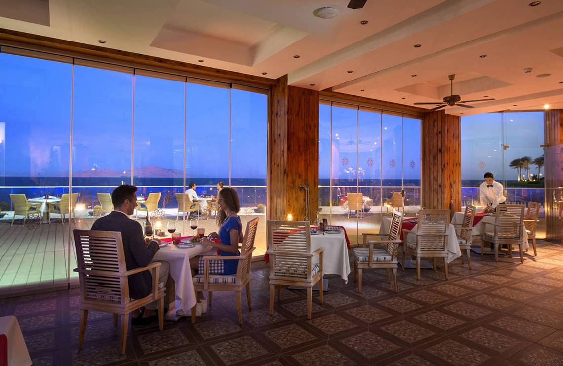 Paar sitzt bei einem romantischen Abendessen im Restaurant des Sunrise Arabian Beach Resort.