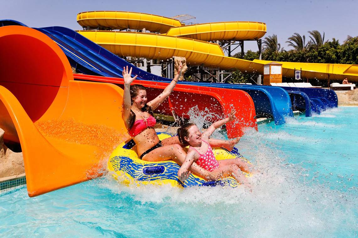 Zwei junge Frauen auf einer gelben und blauen Wasserrutsche im Pickalbatros Royal Moderna Resort.