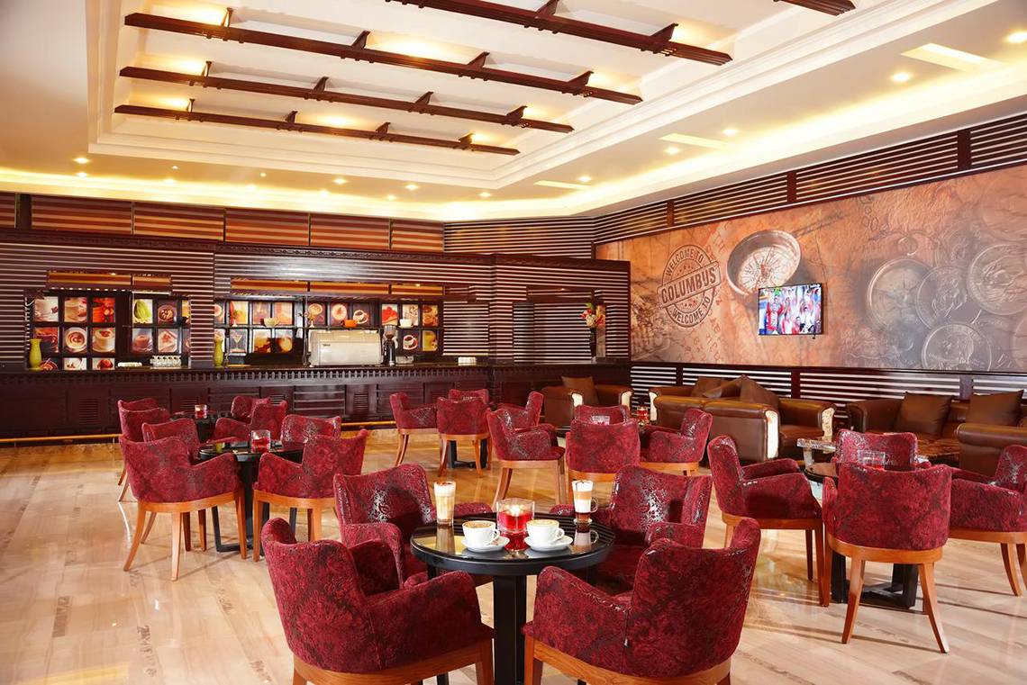 Innenansicht des Cafés im Pickalbatros Royal Moderna Resort mit roten Stühlen und Tischen.