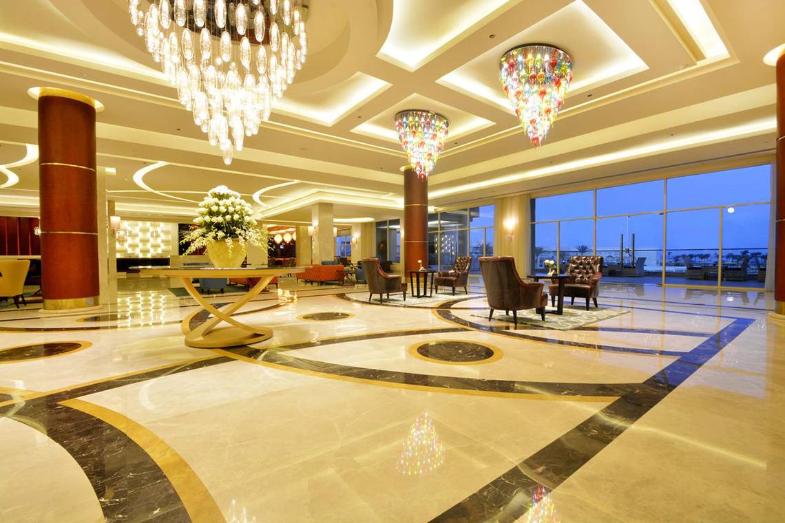 Empfangshalle des Pickalbatros Royal Moderna Resort mit großen Kronleuchtern und Marmorboden.
