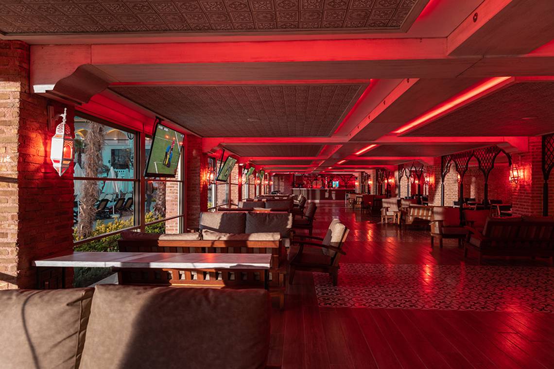 Loungebereich im Swandor Hotels & Resorts Topkapi Palace mit roten Beleuchtungselementen und Sofas.