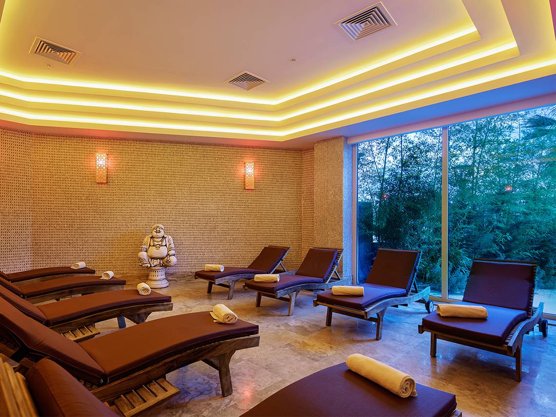 Innenansicht der Sauna im Crystal Waterworld Aqua Collection Hotel mit Lounge-Liegestühlen und Buddha-Statue.