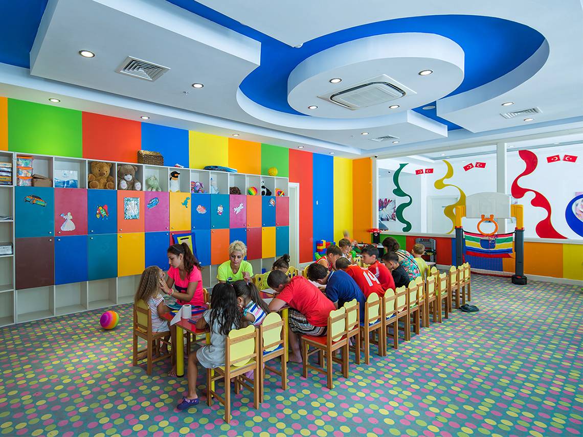 Kinder sitzen um einen Tisch im Spielzimmer des Crystal Waterworld Aqua Collection Hotels.