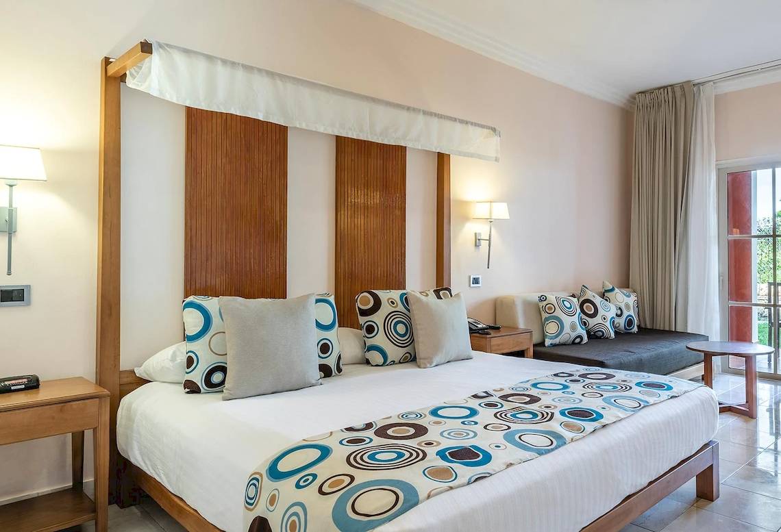Schlafzimmer im Marien Puerto Plata Hotel mit großem Bett, dekorativen Kissen und moderner Einrichtung.