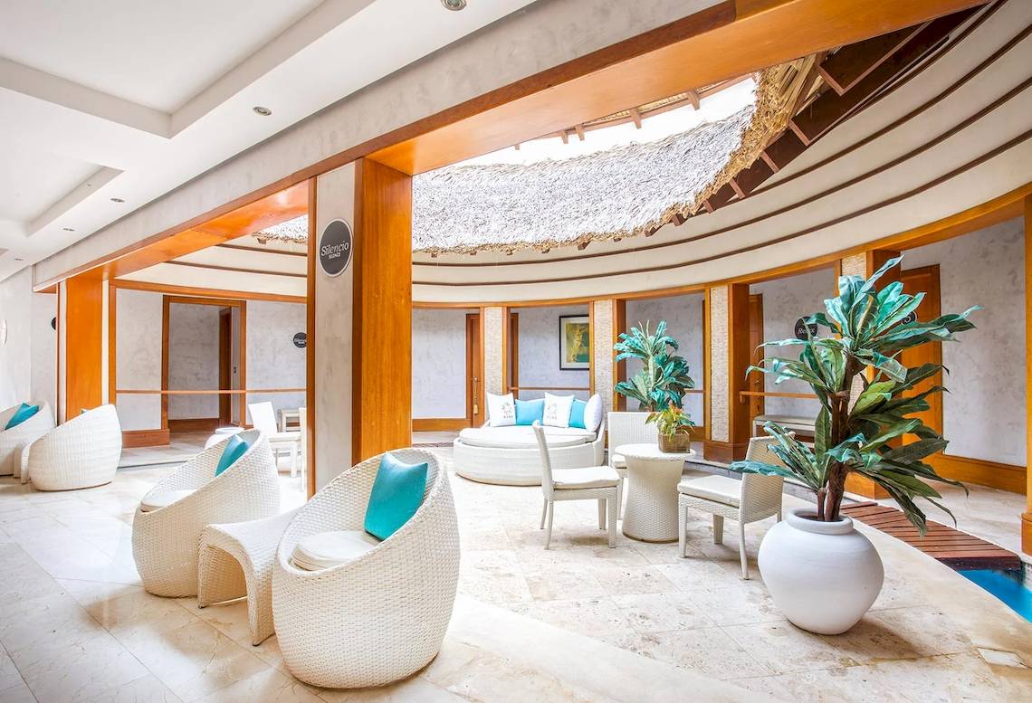 Lounge-Bereich des Marien Puerto Plata Hotels mit weißen Möbeln und Pflanzen.