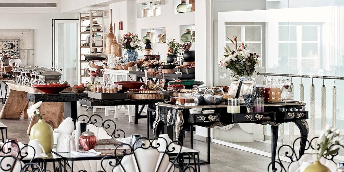 Frühstücksbuffet im Myconian Villa Collection Hotel mit verschiedenen Gerichten und Tischdekoration.