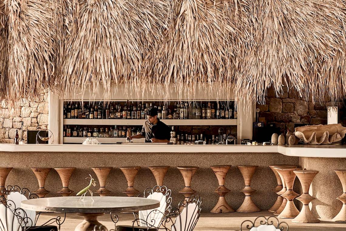 Bar der Myconian Villa Collection mit Barkeeper hinter der Theke.