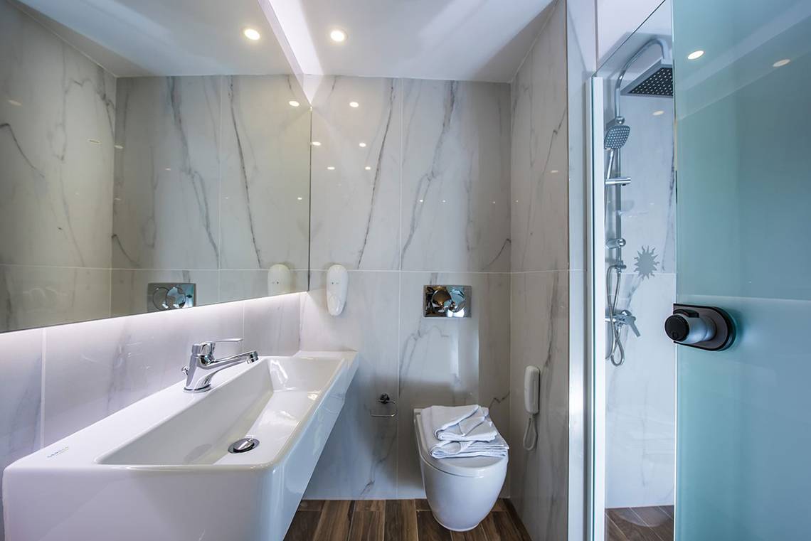 Badezimmer im Gouves Water Park Holiday Resort mit weißen Marmorfliesen und modernen Armaturen.