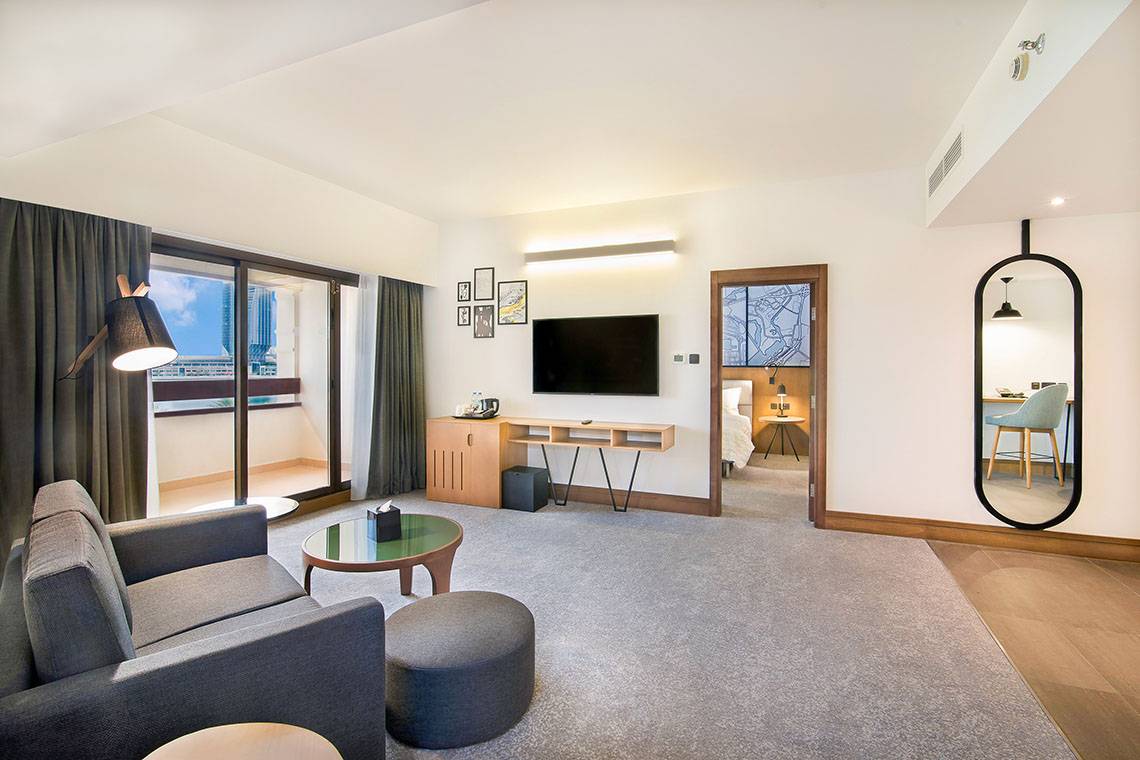 Suite-Zimmer im Le Meridien Abu Dhabi mit Wohnzimmer und Schlafbereich.