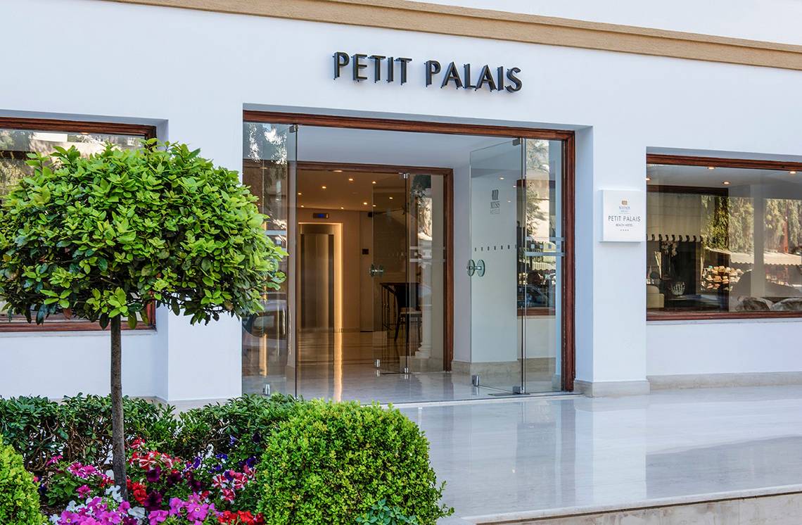 Foto des Eingangsbereichs des Petit Palais Hotels mit Blumen und Pflanzen davor