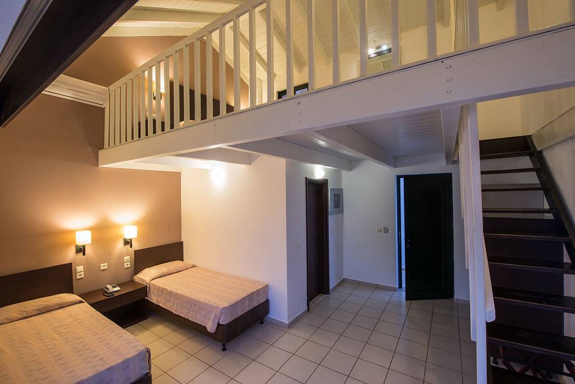 Doppelzimmer im Gouves Water Park Holiday Resort mit zwei Betten, einer Galerie und einer Treppe.