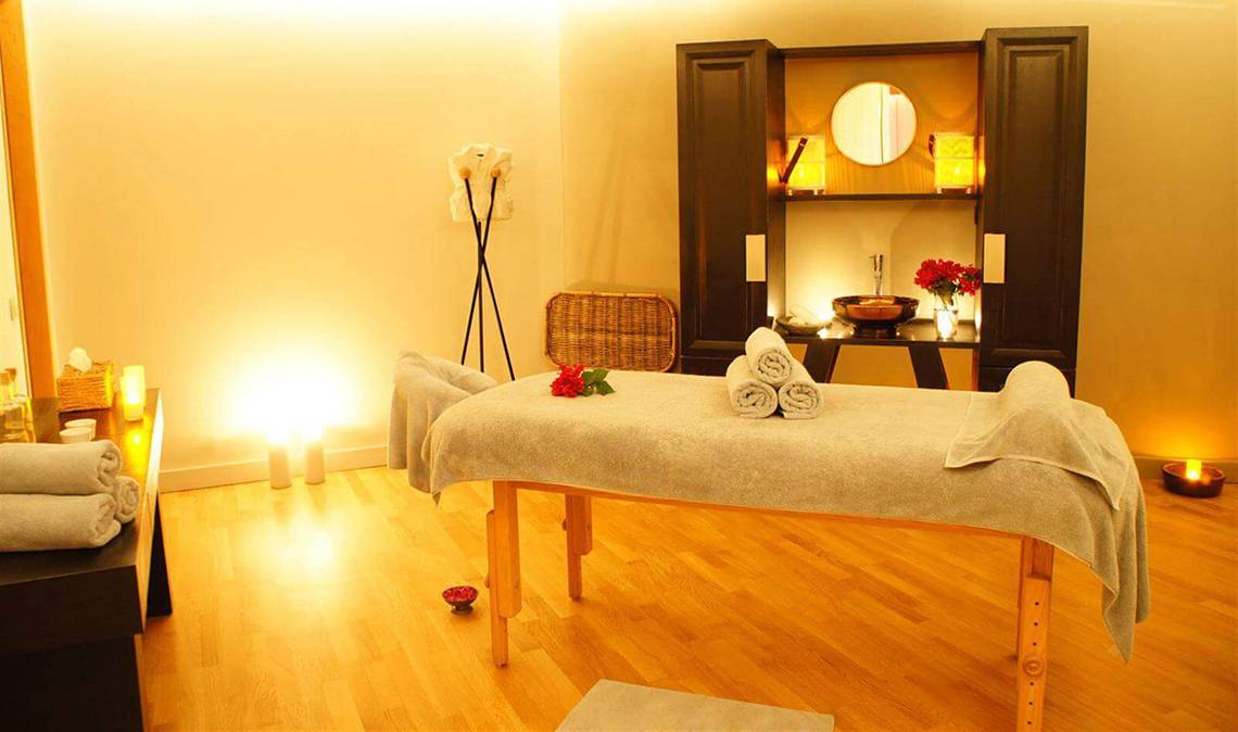 Spa-Behandlungsraum im Marmara Bodrum mit Massagetisch, Kerzen und Dekor.