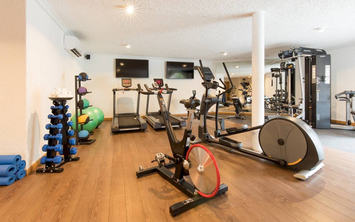Fitnessraum im Seasense Boutique Hotel & Spa mit Laufbändern, Rudergeräten und Hanteln.
