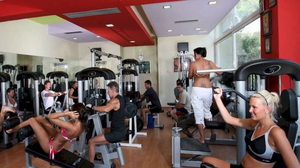 Fitnessstudio im Cathrin Hotel mit verschiedenen Geräten und trainierenden Personen.
