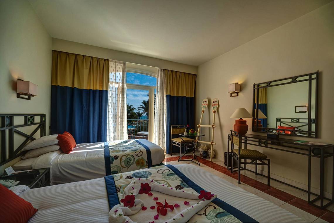 Zimmer im LABRANDA Club Paradisio El Gouna mit zwei Betten, Dekor und Ausblick auf das Meer.